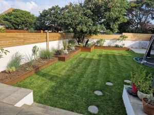 four corten steel retaining walls at various heights being used as a planting border in an outdoor garden