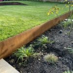 Corten steel retaining wall in a stepped garden lawn setting
