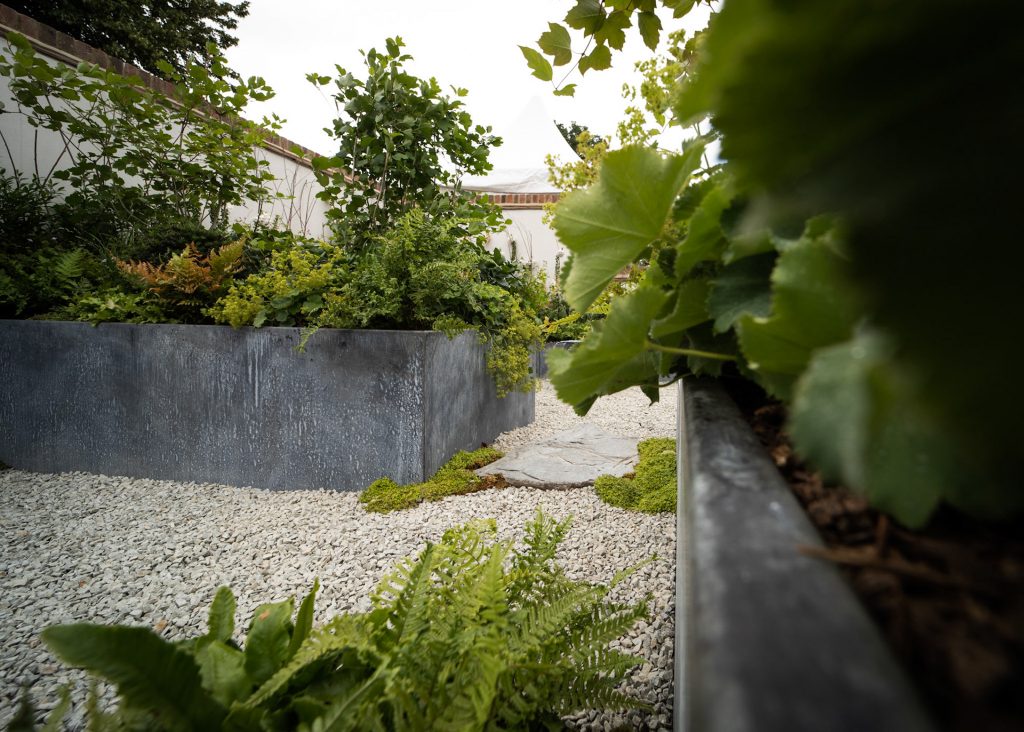 Corten steel trough edging beside a gravel garden path